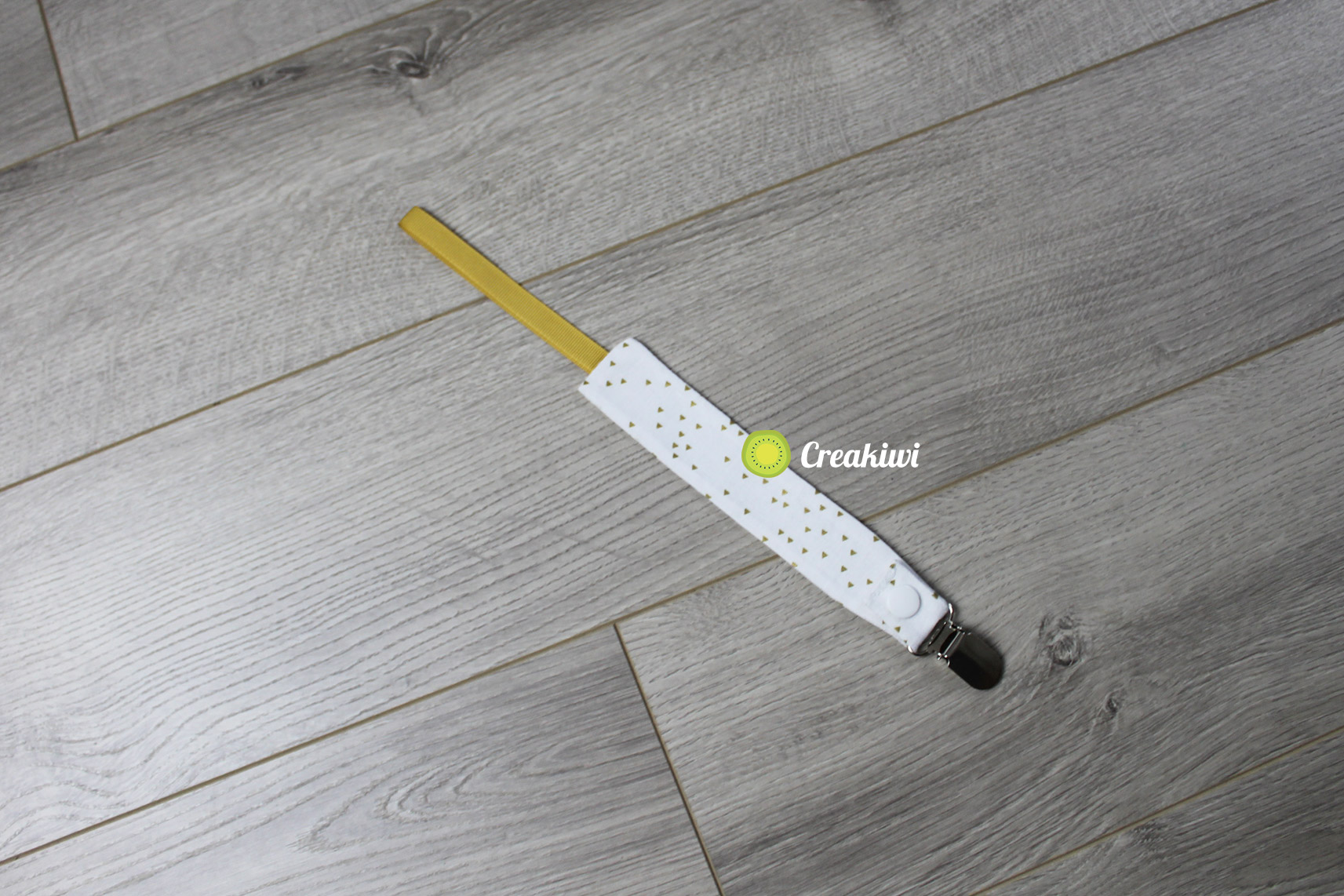 Attache tétine pince métal ruban doré et motif doré